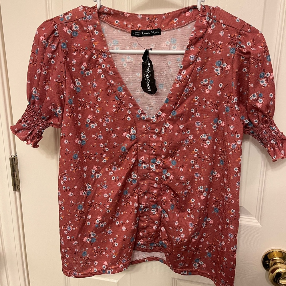 Juniors Medium floral short sleeve dressy top.